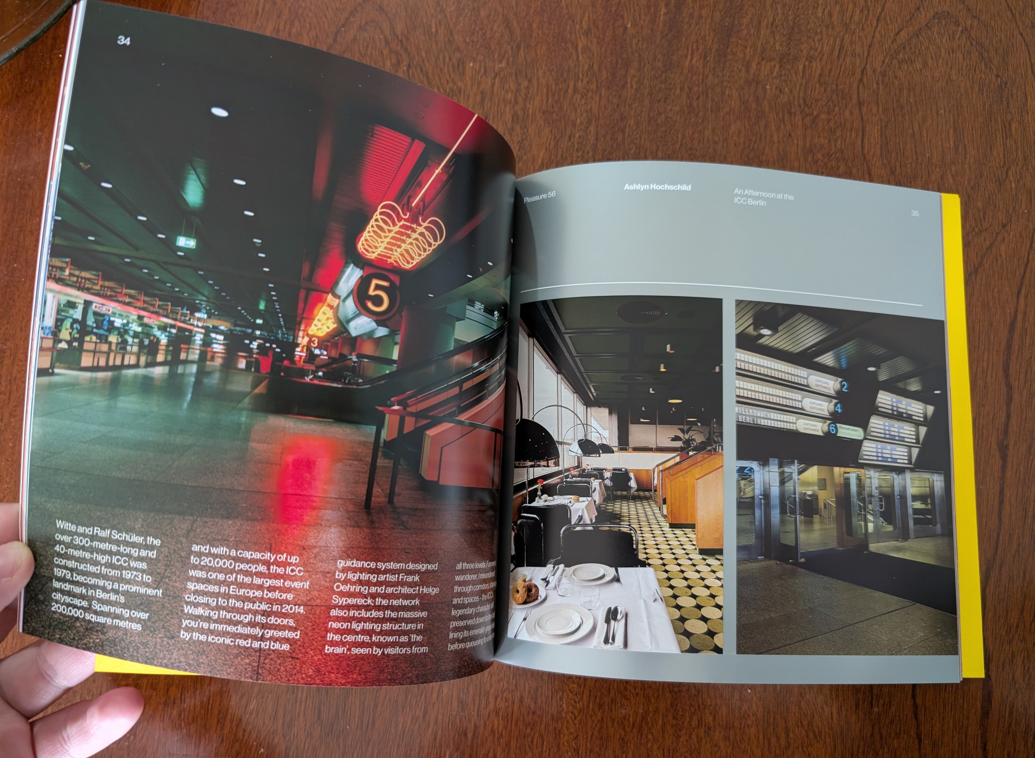 A zine being held open, with photos of the ICC interior in the background